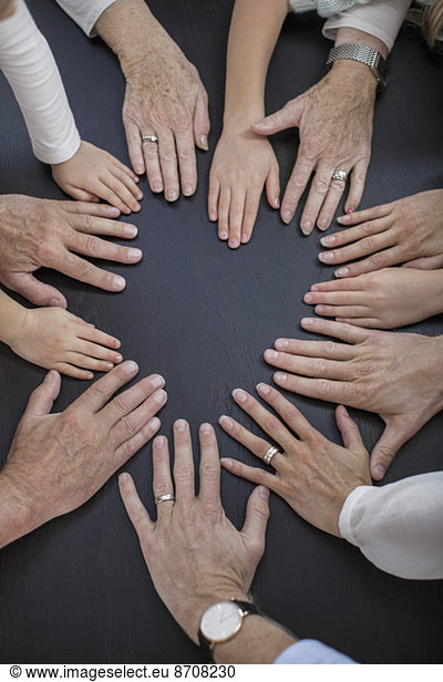 Directly above shot of multi-generation family placing hands in circle