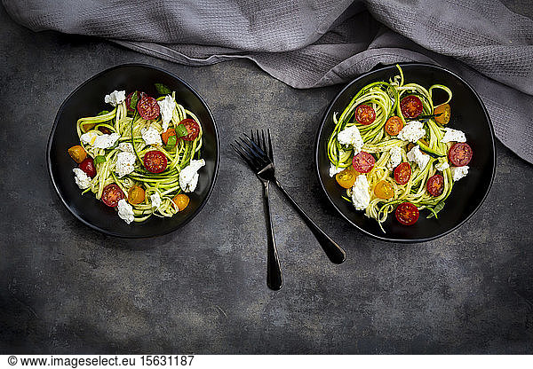 Directly above shot of vegetable salad served in bowls with forks by napkin on table