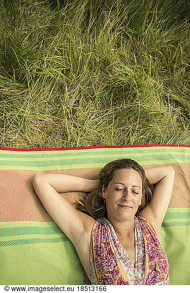Directly above shot of woman resting on picnic blanket on meadow  Bavaria  Germany