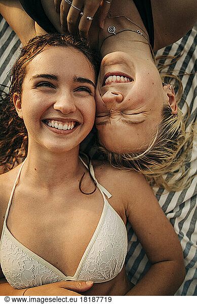 Directly above view of happy female friends lying down together during vacation