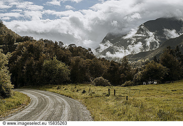 dirt road curls through mountain landscape  South Island New Zealand