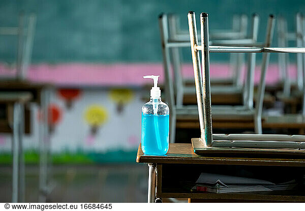 Disinfectant at elementary school student classroom desk.