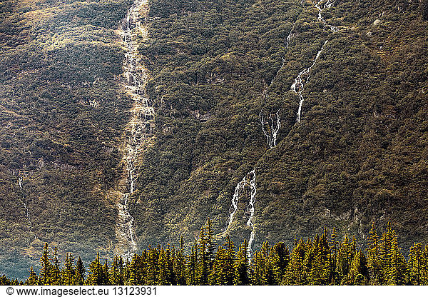 Distant view of waterfalls on green mountain