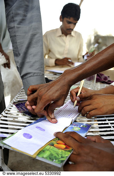 Distribution by a charity organisation after the flood disaster in 2010  beneficiaries signing with their fingerprint  Muzaffaragarh  Punjab  Pakistan  Asia