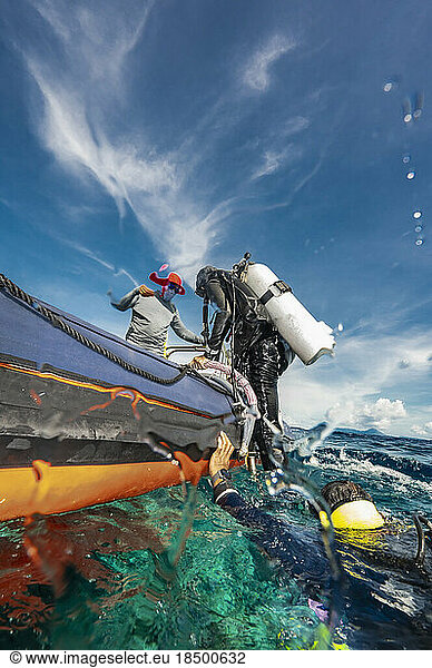 Diver climbing into dinghy after a dive in Banda Sea