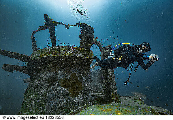 Diver exploring the wreck of the Sattakut close to Koh Tao