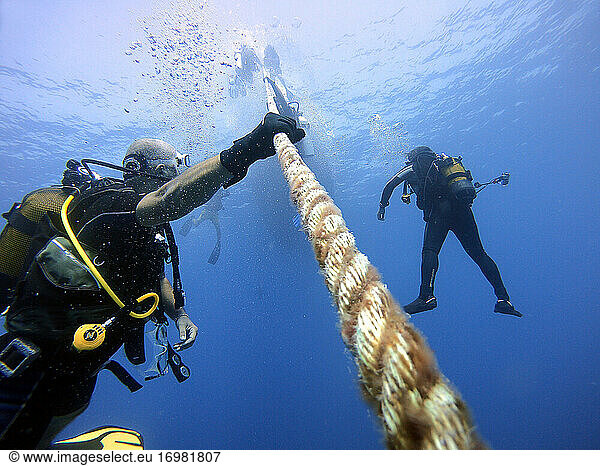 Divers hold onto the boat rope to wait for the surface. Antalya Turkey