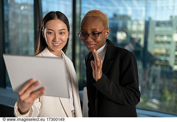 Diverse businesswomen greeting online colleague