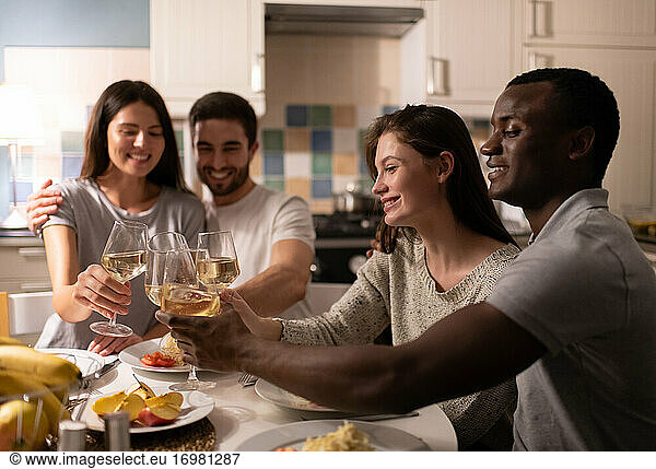 Diverse couple proposing toast to friends