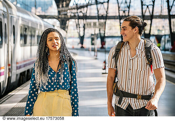 Diverse couple walking on platform