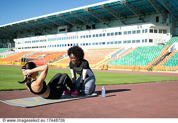 Diverse female athletes doing abs exercise