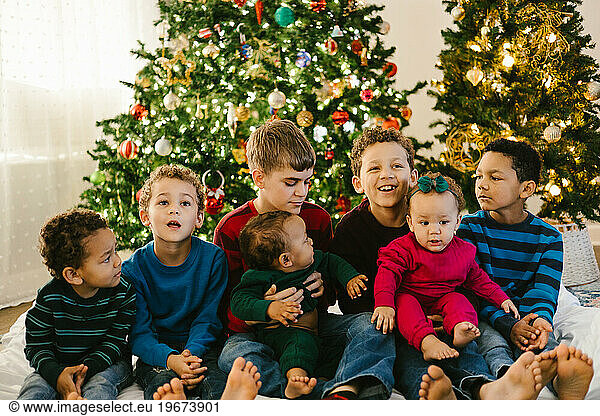 Diverse large family with lots of children in front of Christmas tree