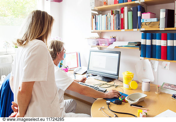 Doctor and nurse looking at computer monitor