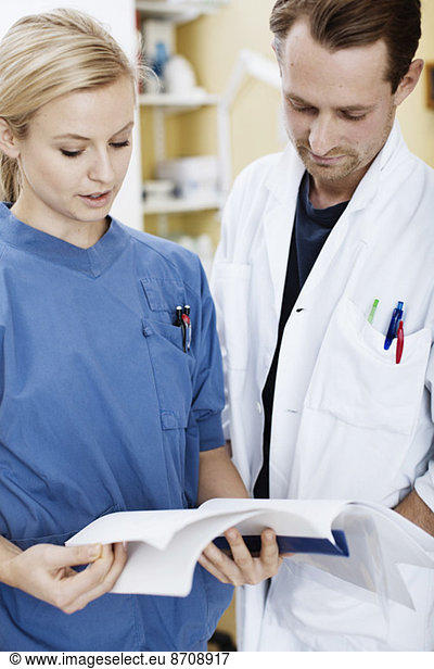 Doctor and nurse reading file in hospital