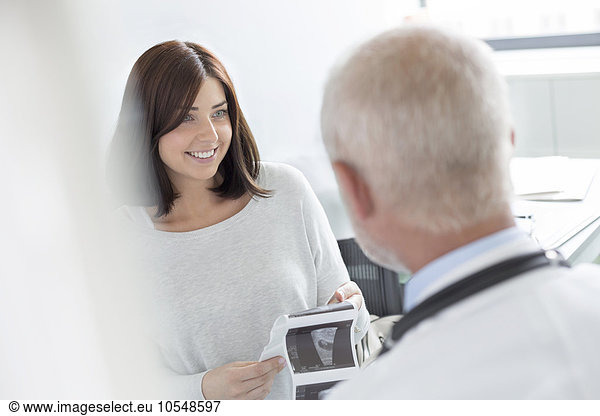 Doctor and patient looking at ultrasound x-rays in doctor’s office