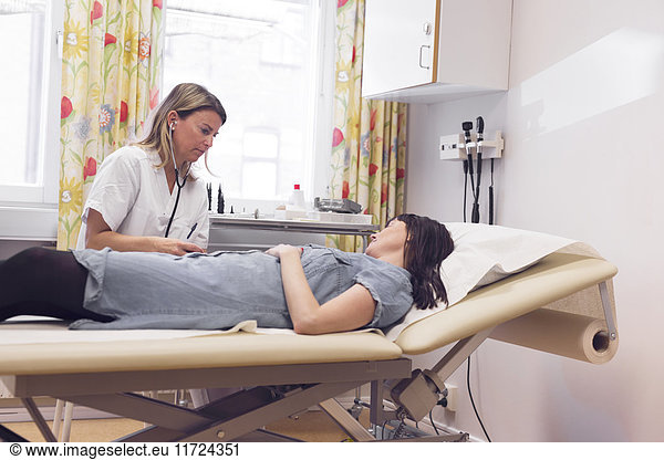 Doctor examining mid adult woman