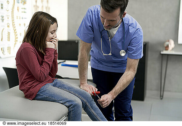 Doctor examining patient with reflex hammer