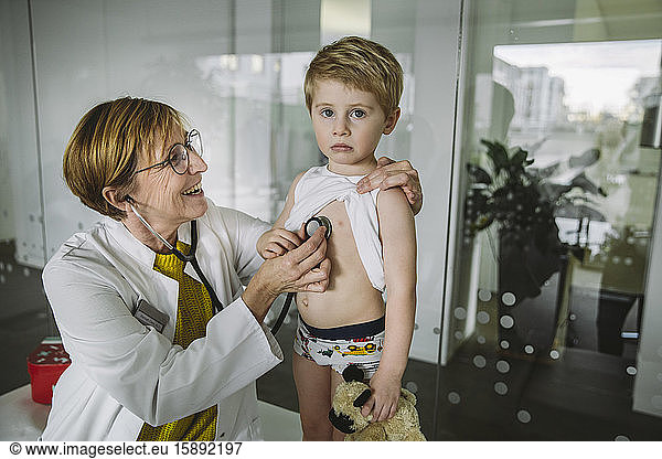 Doctor examining toddler boy with a stethoscope