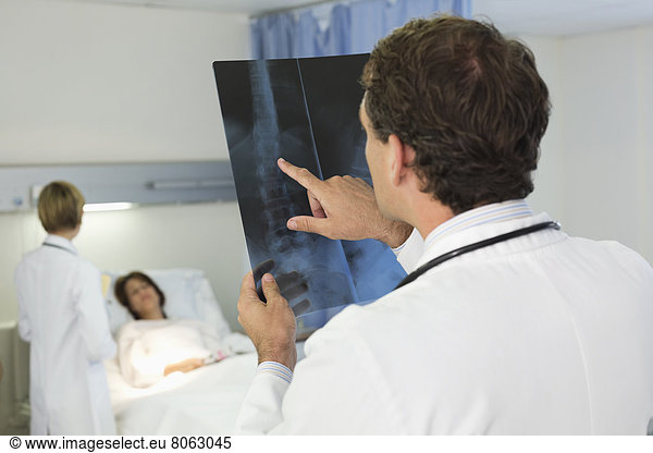 Doctor examining x-rays in hospital room