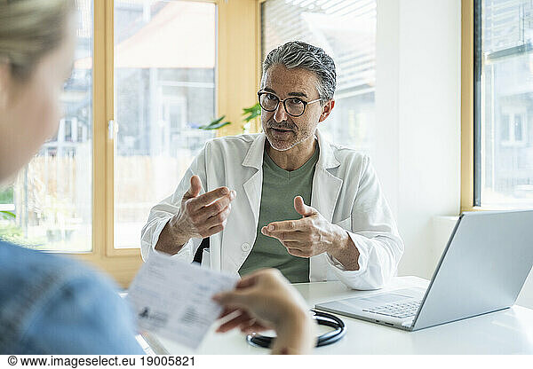 Doctor explaining medical report to patient in clinic