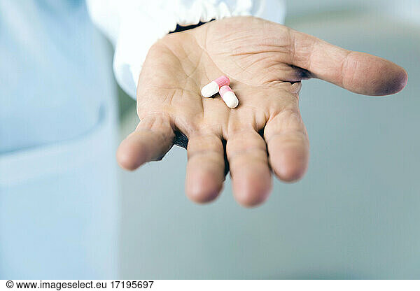 Doctor holding pills in hand