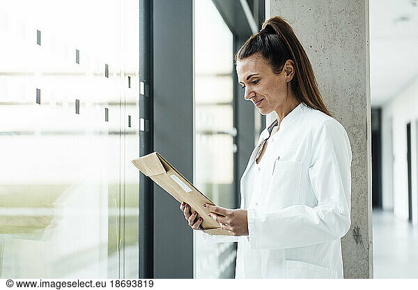 Doctor reading document standing in hospital