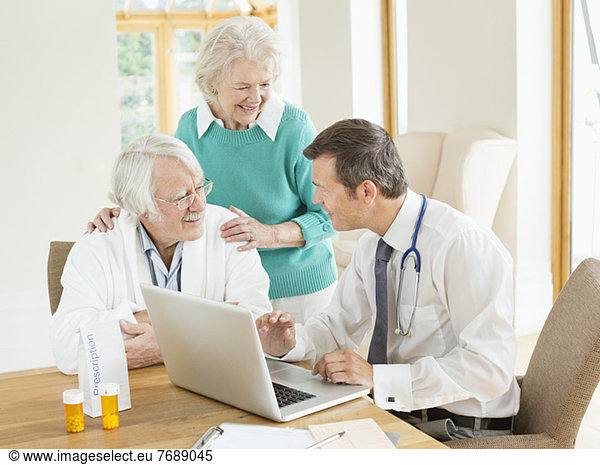 Doctor speaking with older patients at house call