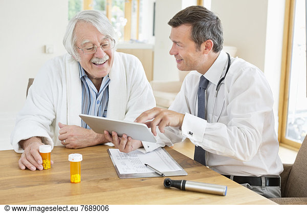 Doctor talking to older patient at house call