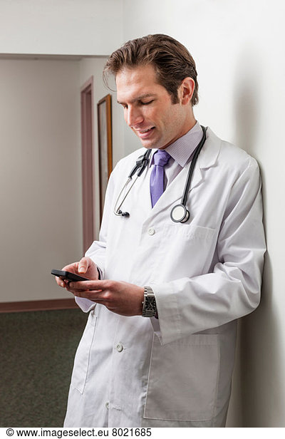 Doctor using mobile phone in hospital corridor