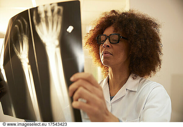 Doctor with eyeglasses examining X-ray in medical clinic at hospital