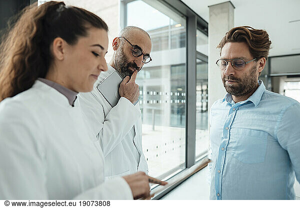 Doctors discussing over document with patient