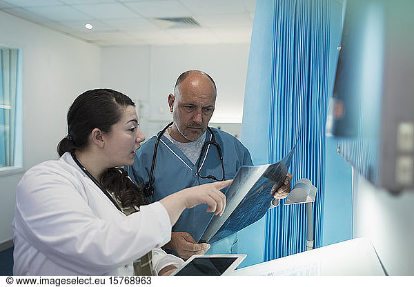 Doctors discussing x-rays in hospital room