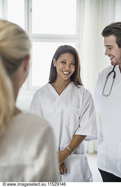 Doctors standing and talking with woman