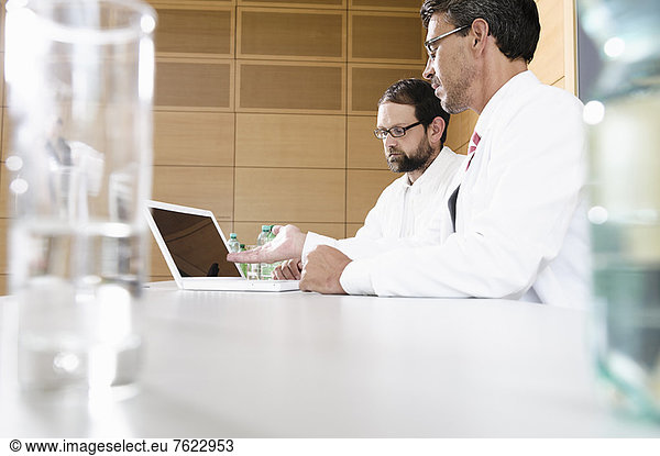 Doctors using laptop at desk