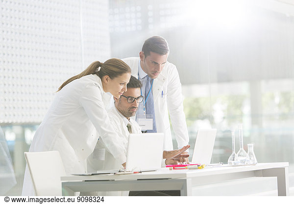 Doctors using laptop in laboratory