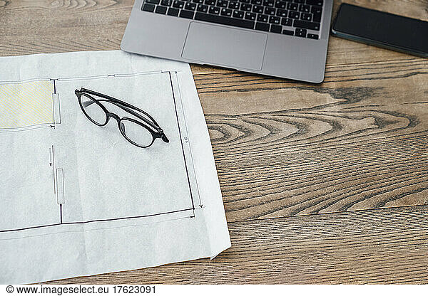 Document  eyeglasses and laptop on desk in office