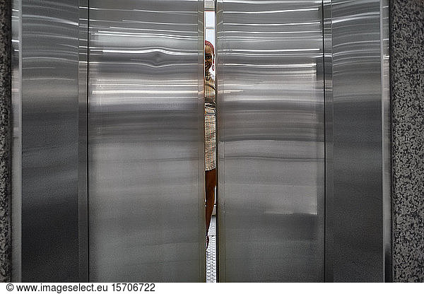 Doors closing of an elevator with a young woman inside