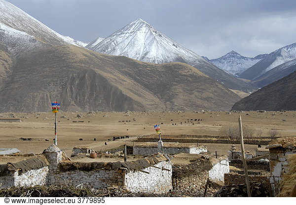 Dorf vor schneebedeckten Bergen am Kloster Reting Tibet China