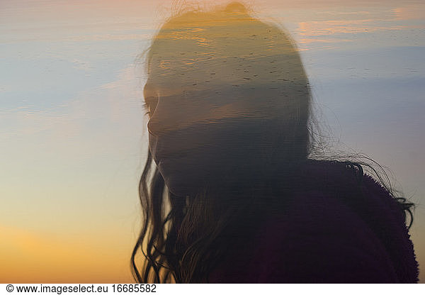 double exposure of girl's silhouette at sunrise