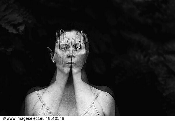 Double exposure portrait of a female behind hands