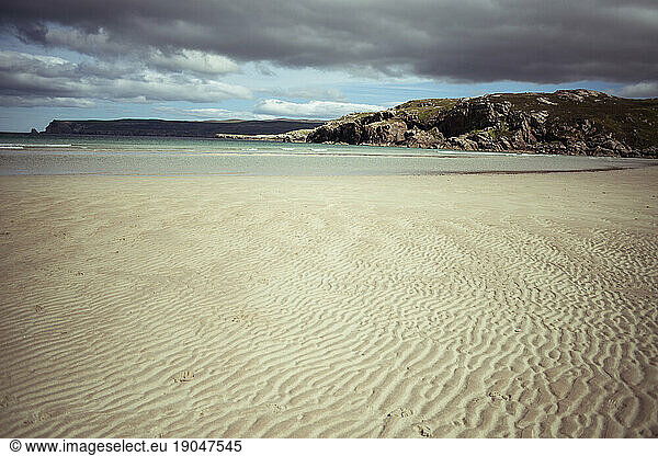 Dramatic clouds over remote white sandy beach
