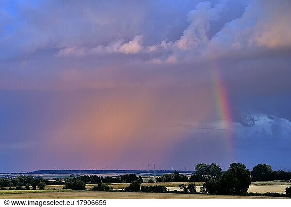 Dramatic light atmosphere  rainbow next to a luminous thundercloud over the Wetterau  Hesse  Germany  Europe