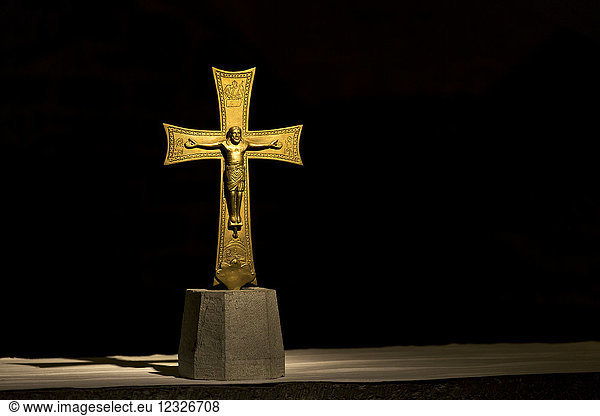 Dramatisch beleuchtetes goldenes Kruzifix vor schwarzem Hintergrund; Florenz  Toskana  Italien