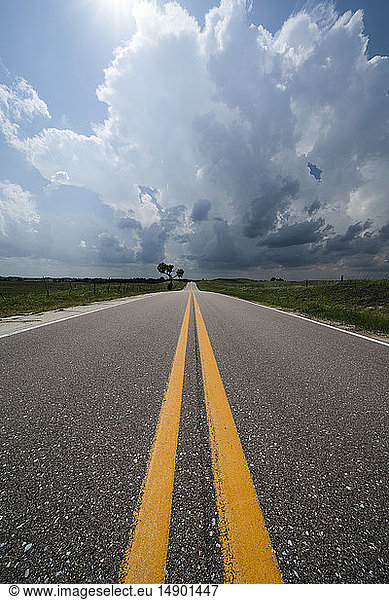 Dramatischer Himmel über der Straße und der Landschaft während einer Sturmjagd im Mittleren Westen der Vereinigten Staaten; Kansas  Vereinigte Staaten von Amerika