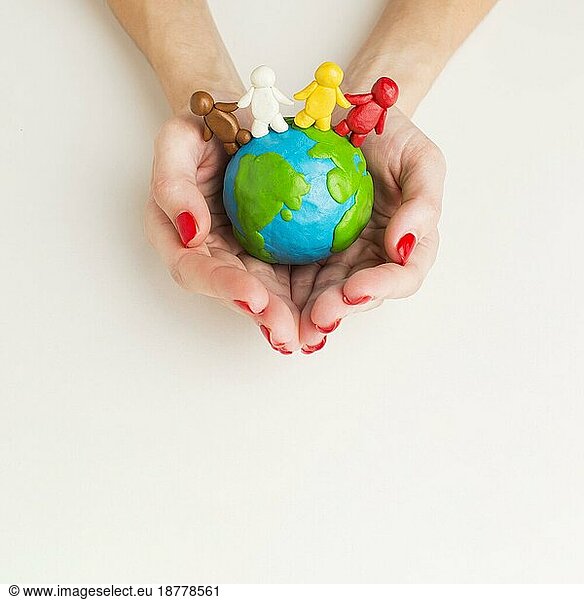 Draufsicht Hände halten Globus mit Menschenfiguren