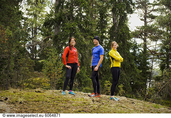 Drei Athleten im Wald stehen