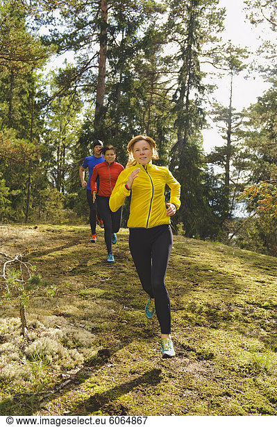 Drei Athleten Joggen durch Wald
