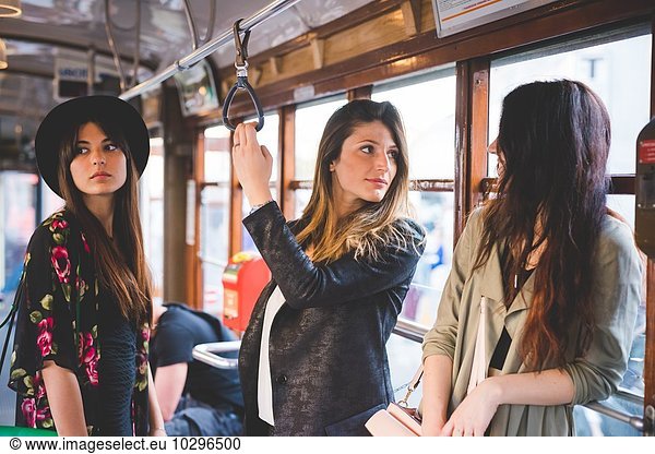 Drei junge Frauen reisen mit der Stadtbahn