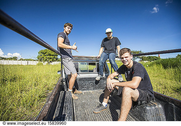 Drei junge Männer fahren in der Ladefläche eines 4x4-Lkw  ländliches Mittelamerika.