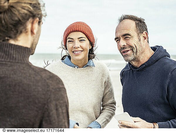 Drei Menschen unterhalten sich am Strand